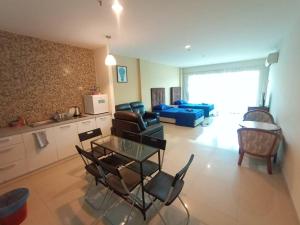 uma sala de estar com um sofá, uma mesa e cadeiras em InstaStay 2-Unit Marina Island Teluk Batik View Lagoon - 1 Bedroom Queen Bed & 2 Single Bed em Lumut