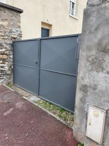 una gran puerta metálica frente a un edificio en Agréable maison de ville à Pacy sur eure en Pacy-sur-Eure