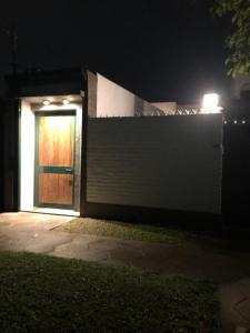 Una casa con una puerta y una valla por la noche en PuntoPeru en Yerba Buena