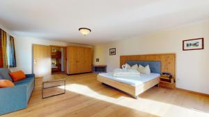 Un dormitorio con una cama y un sofá azul. en Hotel Daxer, en Kirchberg in Tirol