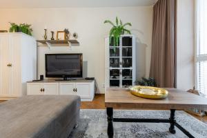 a living room with a table and a flat screen tv at Old Town Vintage Apartment Sturova in Košice