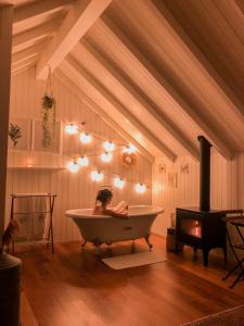 a woman in a bath tub in a room with a stove at Oliveiras Village — Agroturismo in Amarante