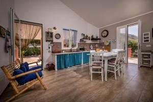 cocina y comedor con mesa y sillas en Villa Agapanthus en Castellammare del Golfo