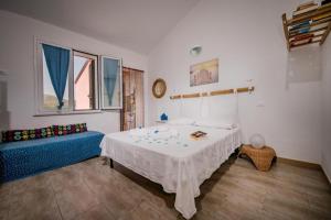 a bedroom with a bed and a blue couch at Villa Agapanthus in Castellammare del Golfo