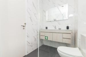 a white bathroom with a toilet and a sink at Casa do Nilo in Sesimbra +29 photos