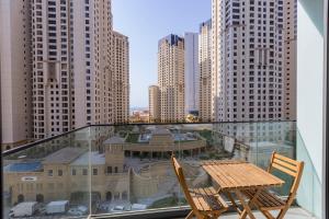 2 Stühle und ein Tisch auf einem Balkon mit Gebäuden in der Unterkunft Liv Residence in Dubai