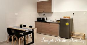 a kitchen with a table and a refrigerator at Bali Residences by Fauzah Muslim Homestay in Melaka