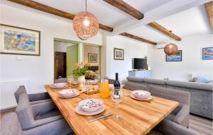 uma sala de jantar e sala de estar com uma mesa de madeira e cadeiras em Cozy Home In Kumrovec With Kitchen em Kumrovec