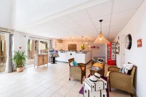 uma sala de estar em plano aberto com cadeiras e uma cozinha em Garden & City Les Bastides de Grimaud em Grimaud
