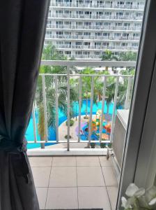 a view of a pool from a hotel room window at SHELL RESIDENCE C9 NEAR AIRPORT & MALL OF ASIA in Manila