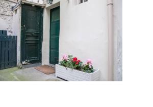 a white crate with flowers in it next to a door at La petite maison parisienne in Levallois-Perret