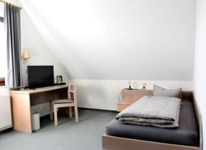 1 dormitorio con 1 cama y escritorio con ordenador en Hotel Garni Haus Dornheim, en Obertshausen