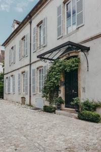 La Maison des Courtines في بون: مبنى أبيض ذو مصاريع زرقاء على شارع