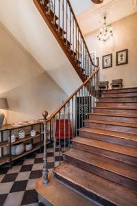 uma velha escadaria numa casa com um piso xadrez em La Maison des Courtines em Beaune
