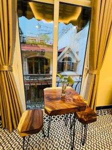 a table and bench in front of a large window at Anam Homestay in Ho Chi Minh City