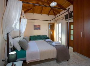 1 dormitorio con cama con dosel y sofá verde en Ifigeneia's Luxury Resort with Private Hot Tub, en Kalathas