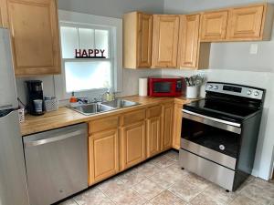 a kitchen with a stove and a sink and a microwave at Spanish Town / Downtown Apartment in Baton Rouge