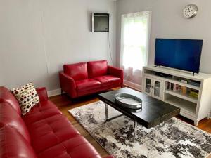 a living room with red furniture and a flat screen tv at Spanish Town / Downtown Apartment in Baton Rouge