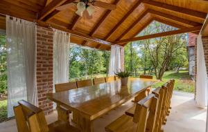 a dining room with a large wooden table and chairs at Villa Nikšić in Otočac