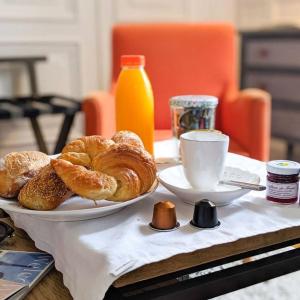 uma mesa com um prato de pastelaria e uma chávena de café em La Maison des Courtines em Beaune