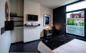 a bedroom with a bed and a large window at Rock Lobster City Lodge in Antwerp