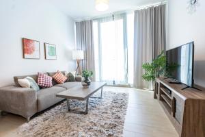ein Wohnzimmer mit einem Sofa und einem TV in der Unterkunft Liv Residence in Dubai