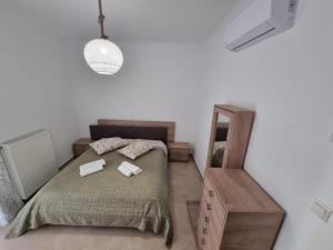 een slaapkamer met een bed met twee handdoeken erop bij AGORA luxury APARTMENT 1 in Loutraki