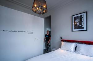 een slaapkamer met een bed en een man die in een spiegel staat bij Rock Lobster City Lodge in Antwerpen
