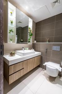 ein Badezimmer mit einem Waschbecken, einem WC und einem Spiegel in der Unterkunft Liv Residence in Dubai