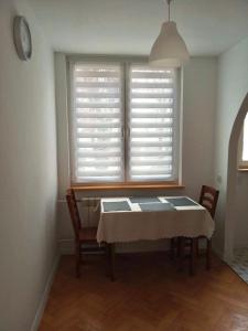 mesa y sillas en una habitación con ventana en Apartament Doris en Ciechocinek