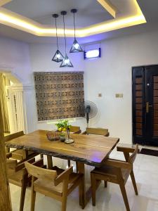 jadalnia z drewnianym stołem i krzesłami w obiekcie Villa Sofia w mieście Abeokuta