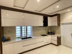 a kitchen with white cabinets and a window at Villa Sofia in Abeokuta