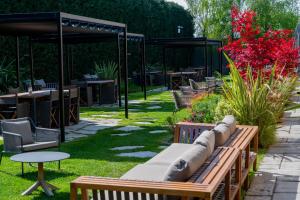 a bench in a garden with tables and chairs at Atena Dolce Vita in Brescia