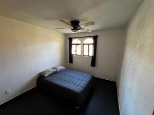 a bedroom with a bed and a ceiling fan at Casa Lían in Cuernavaca