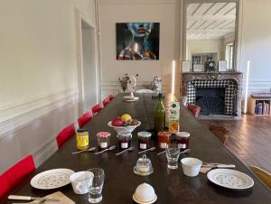 a dining room table with plates and bottles of wine at Parc de Lesseps in Meunet-Planches