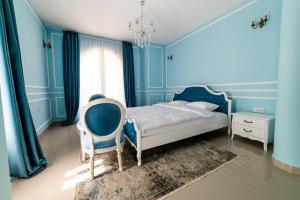1 dormitorio azul con 1 cama y 1 silla en Vila Biser Dunava (Pearl of Danube Villa) en Smederevo