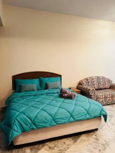 uma cama com um edredão azul num quarto em Hijauan Studio Unit @ Ocean View Resort em Porto Dickson