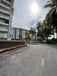 um parque de estacionamento vazio em frente a um hotel em Hijauan Studio Unit @ Ocean View Resort em Porto Dickson