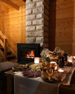 a table topped with plates of food next to a fireplace at Vikendica Pavle in Trebinje