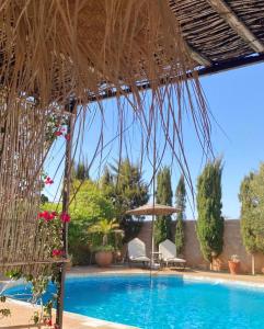 a resort with a swimming pool and a thatched umbrella at Maison Mimosa, lovely 3 bedroom villa with a Large pool in Essaouira +31 photos