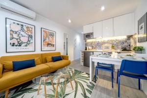馬貝拉的住宿－XPCE MARINO 2 MARBELLA，一间带黄色沙发的客厅和一间厨房