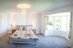 Habitación blanca con cama y ventana en Country Crabtree Bungalow with large wild garden, 