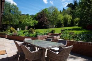un patio con mesa y sillas en un jardín en Country Crabtree Bungalow with large wild garden, 