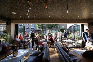 a group of people sitting at tables in a restaurant at Darlington - 2 Bedroom Luxury Apartment by Mint Stays in Bristol