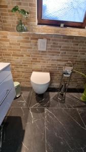 een badkamer met een wit toilet op een marmeren vloer bij FP-Immobilien in Harsum