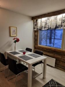 a dining room table with chairs and a window at Polaris Homes Huippu in Syöte