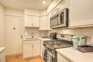 a kitchen with white cabinets and a stove top oven at Baltimore Townhome Near Oriole Park with AandC! in Baltimore