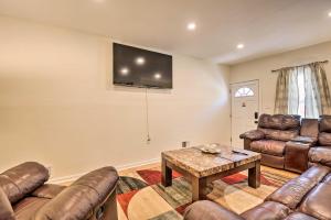 a living room with leather furniture and a flat screen tv at Baltimore Townhome Near Oriole Park with AandC! in Baltimore