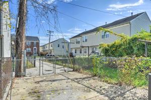 a chain link fence in a residential neighborhood with houses at Baltimore Townhome Near Oriole Park with AandC! in Baltimore