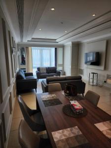 a living room with a table and chairs and a couch at Luxurious 2-bedroom Apartment with Sea View in Doha